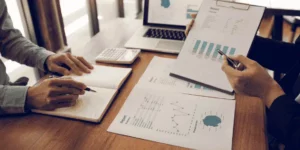 mesa de trabalho com diversas folhas com gráficos e pesquisas