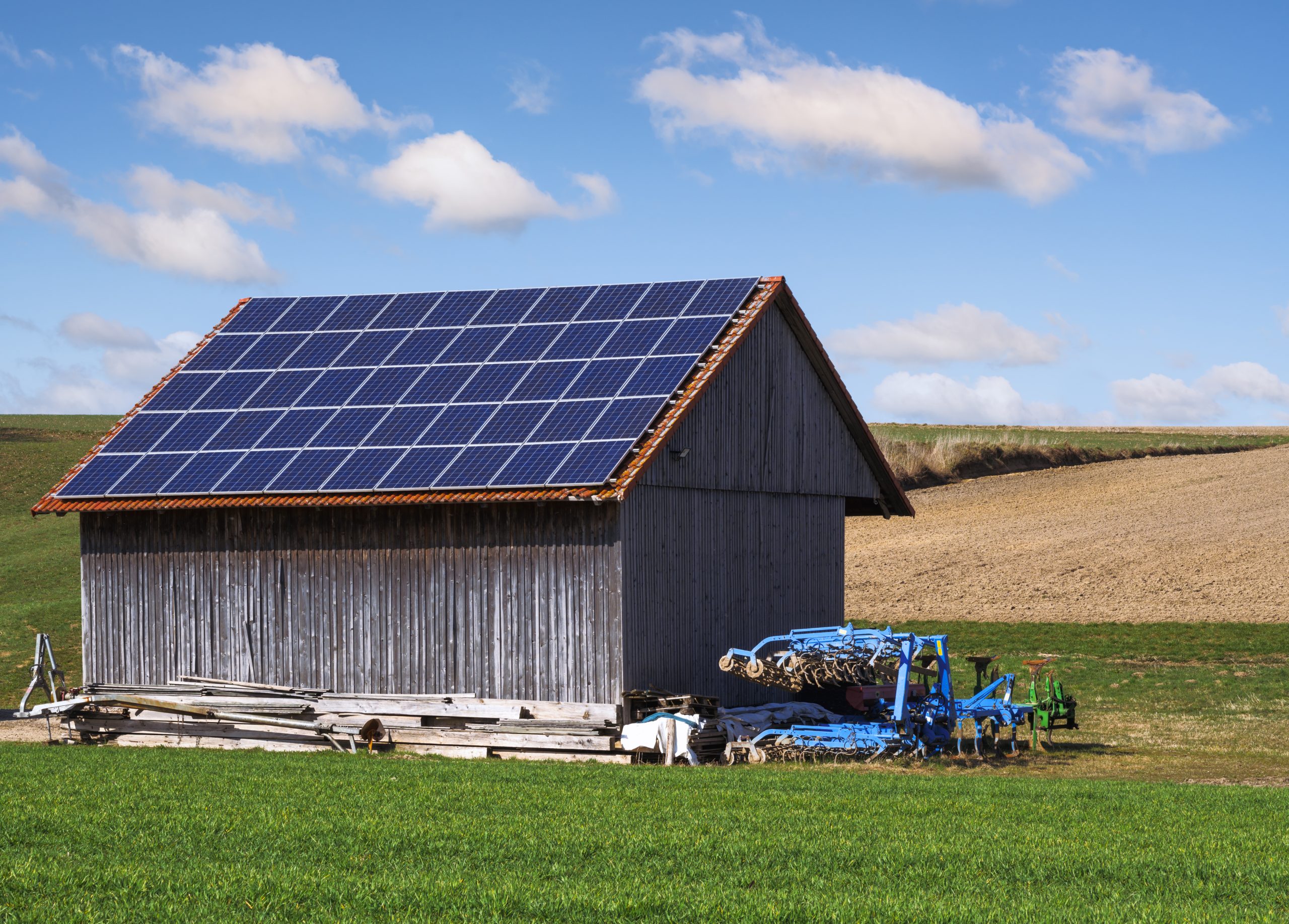 Energia verde com coletores solares no telhado de um edifício agrícola que fez transição energética