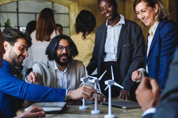 Grupo de líderes reunidos em torno de uma mesa de trabalho tratando do papel do desenvolvimento sustentável