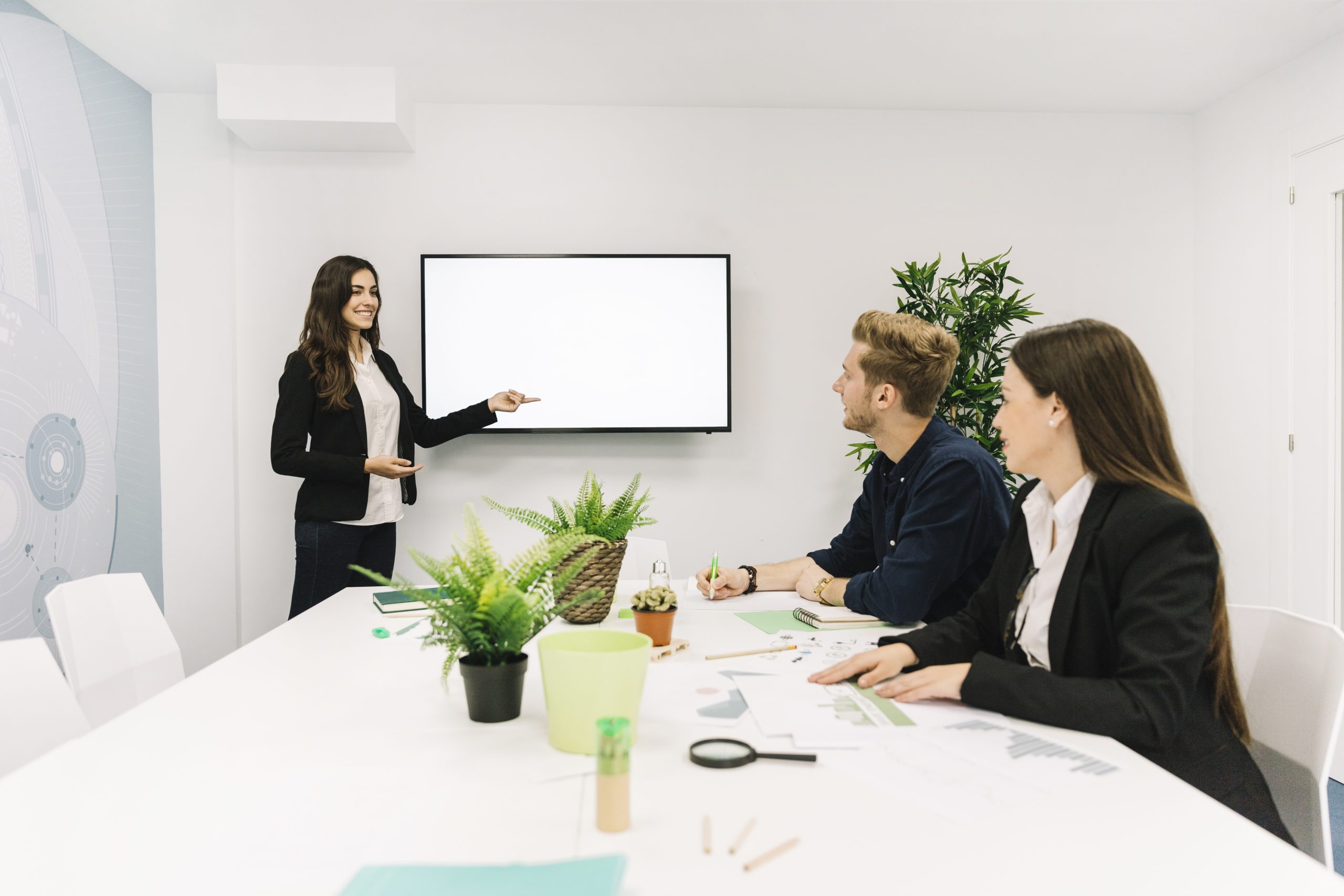 Três pessoas em uma sala de reuniões discutindo a agenda ESG