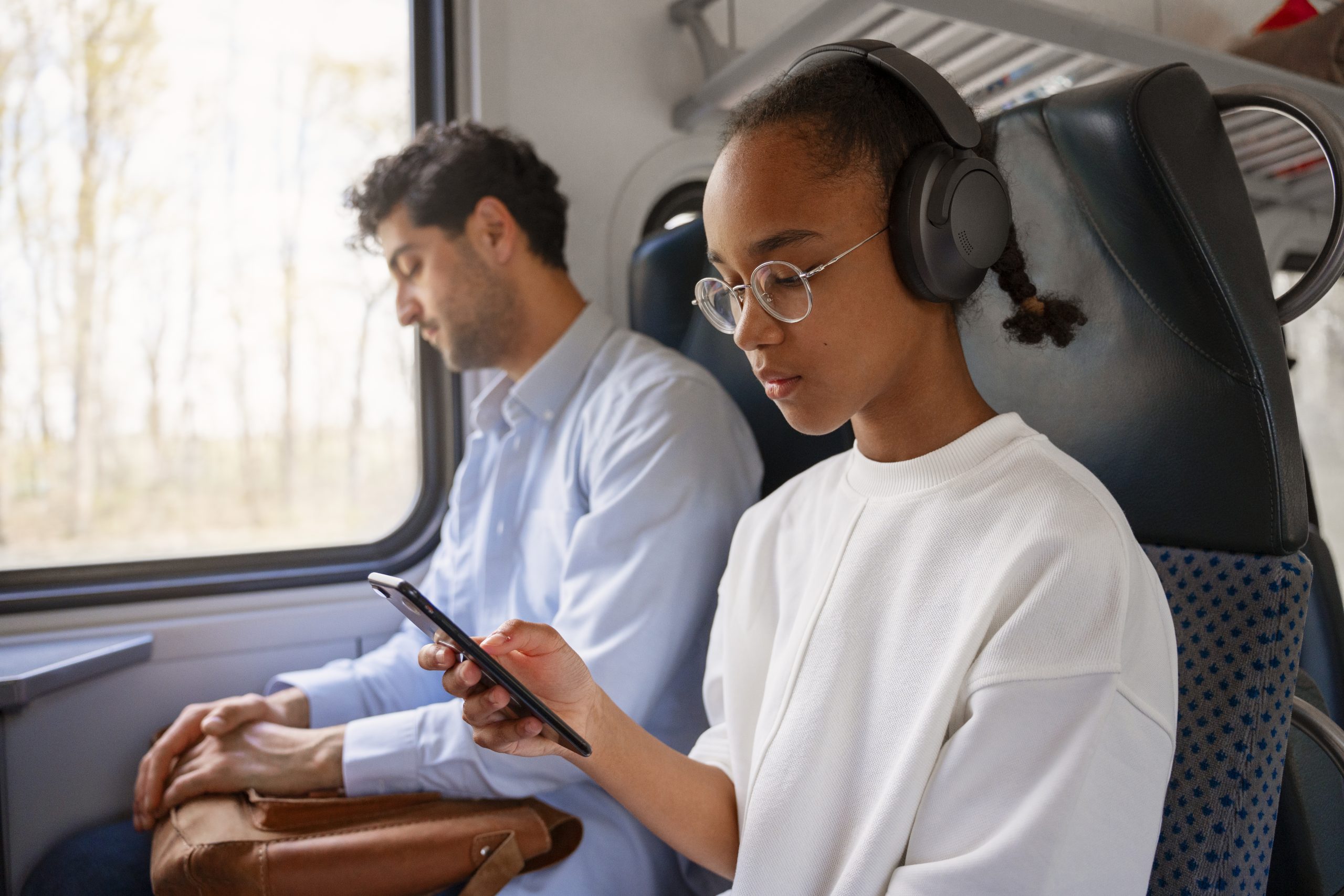 Uma jovem negra estudando pelo celular em uma viagem de ônibus