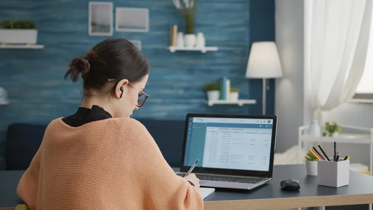 Mulher diante do laptop em ambiente de trabalho. Conceito: Estruturando prompts para ChatGPT