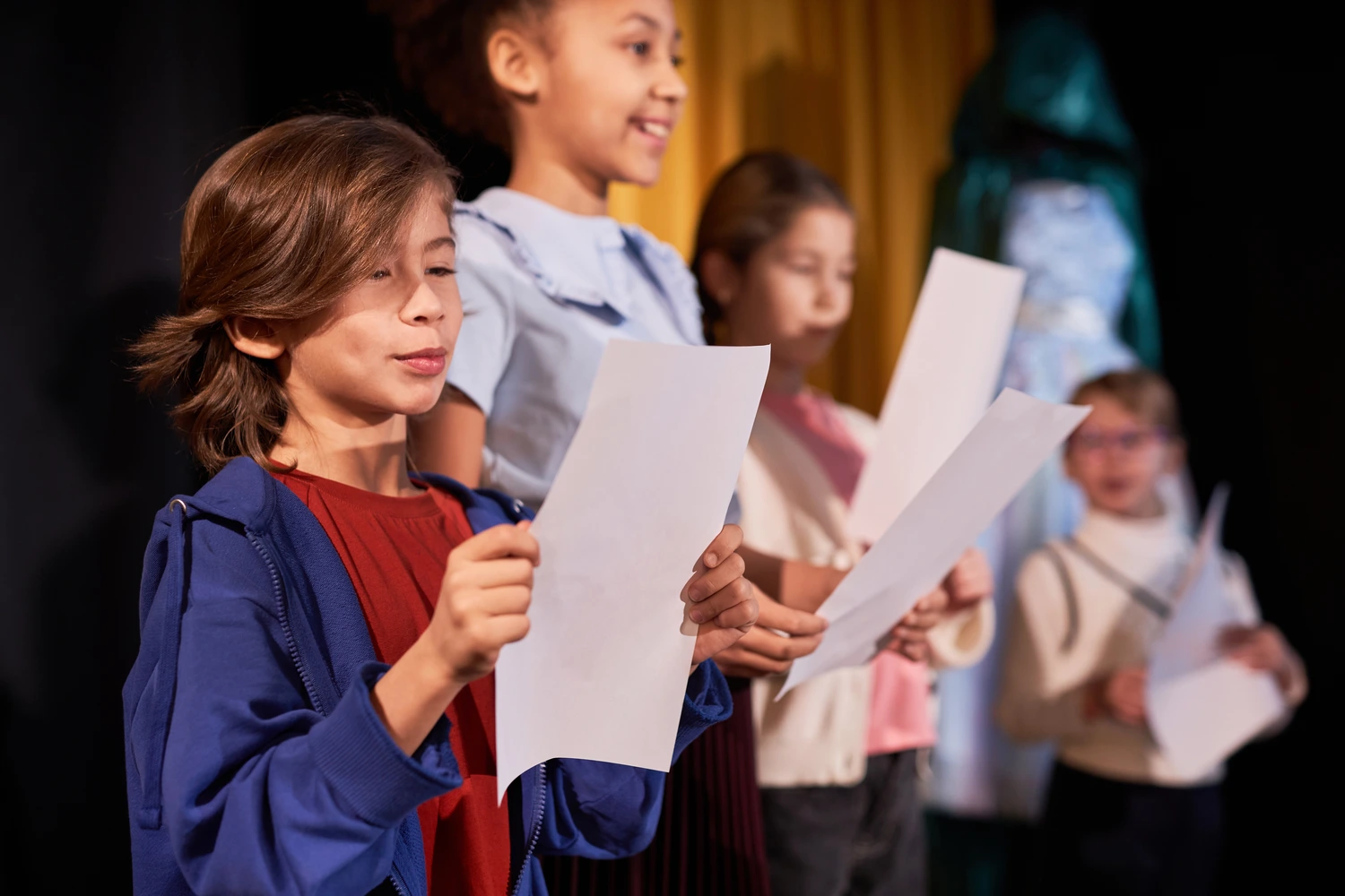 Crianças se apresentam no teatro da escola. Conceito: aplicação das competências gerais da BNCC