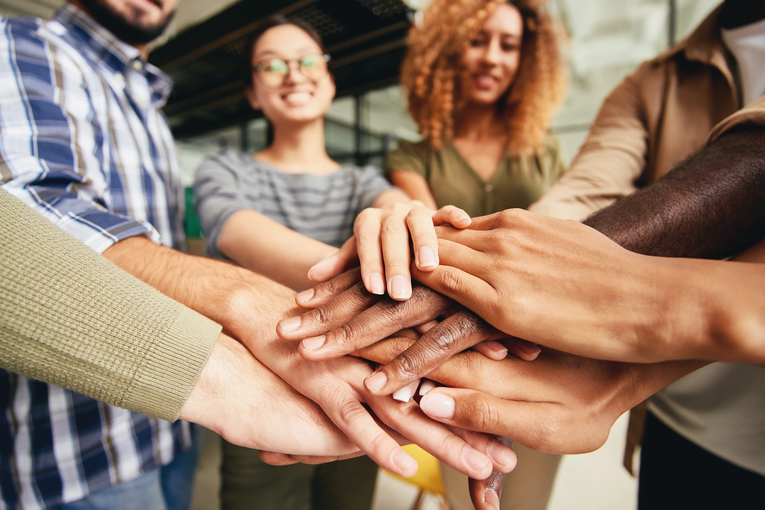 Diversas mãos unidas, representando a diversidade e a equidade em empresas