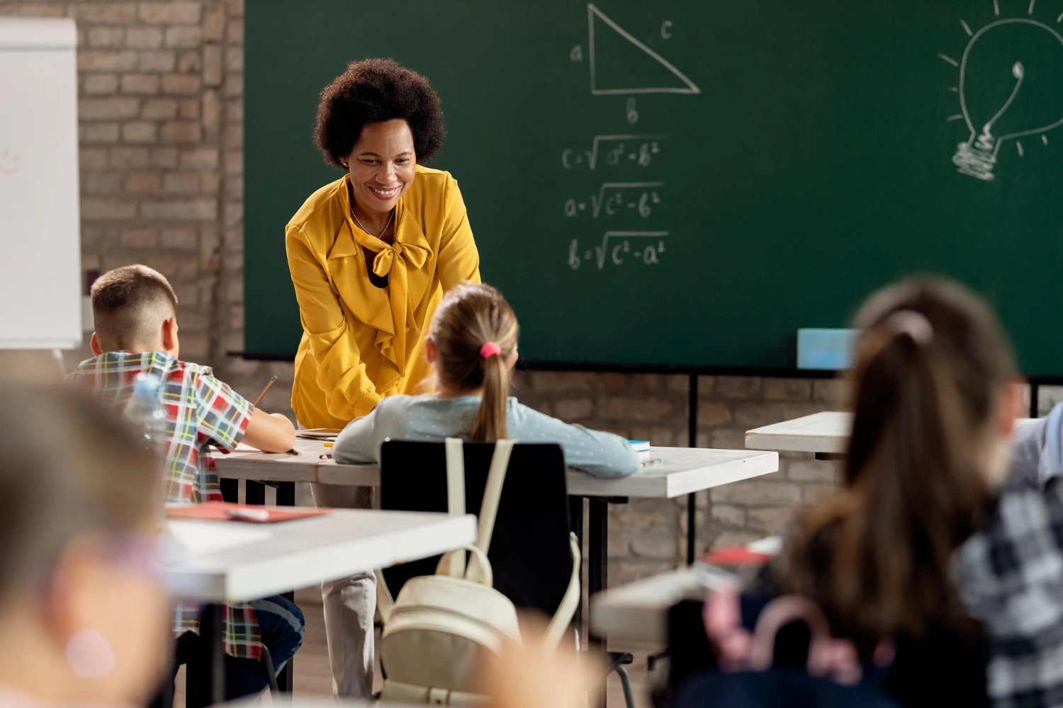 Uma professora de matemática conversa com uma aluna em sala de aula. Conceito: educação no Brasil, desafios e oportunidades.