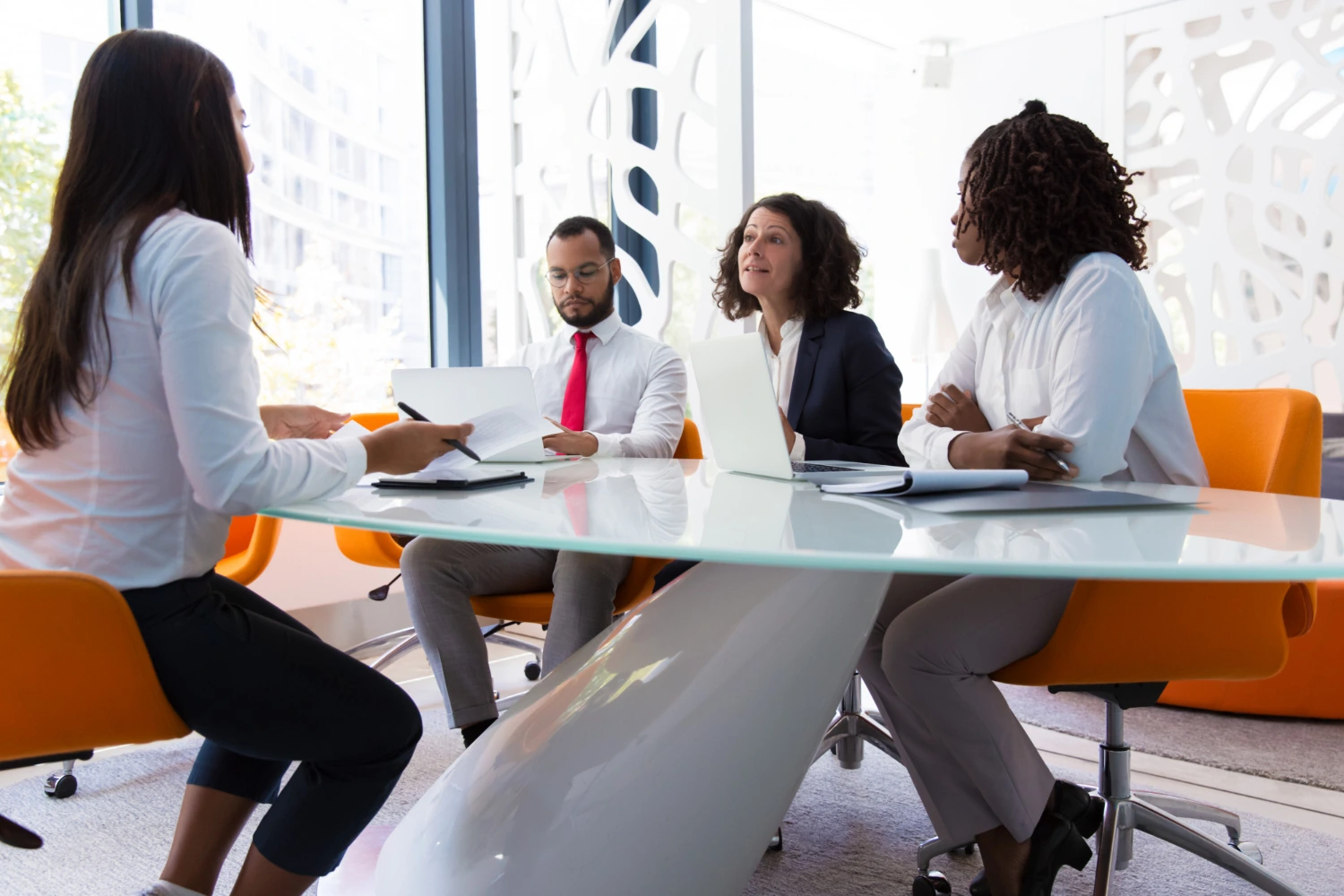 Uma reunião feita por quatro pessoas do RH com uma funcionária, repassando um multisource feedback, ou feedback 360 