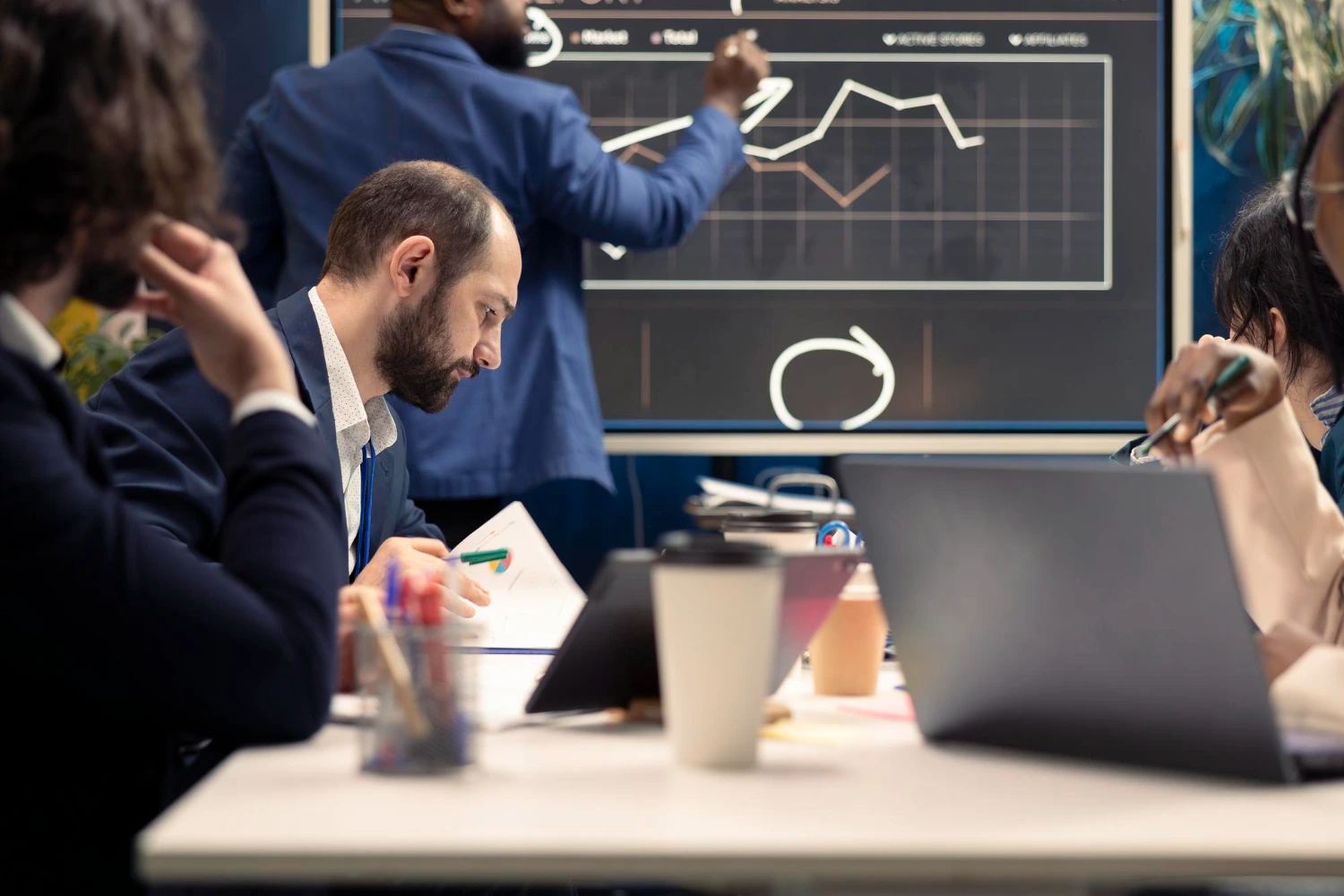 Profissionais analisam gráficos em reunião estratégica, ilustrando decisões baseadas em dados no contexto do empreendedorismo digital.