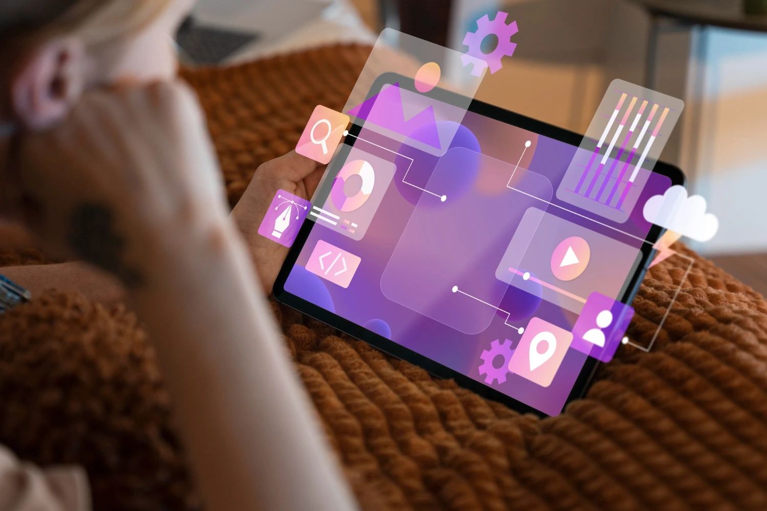 Pessoa utiliza tablet com elementos gráficos digitais, representando processos de criação, análise e gestão no empreendedorismo digital.