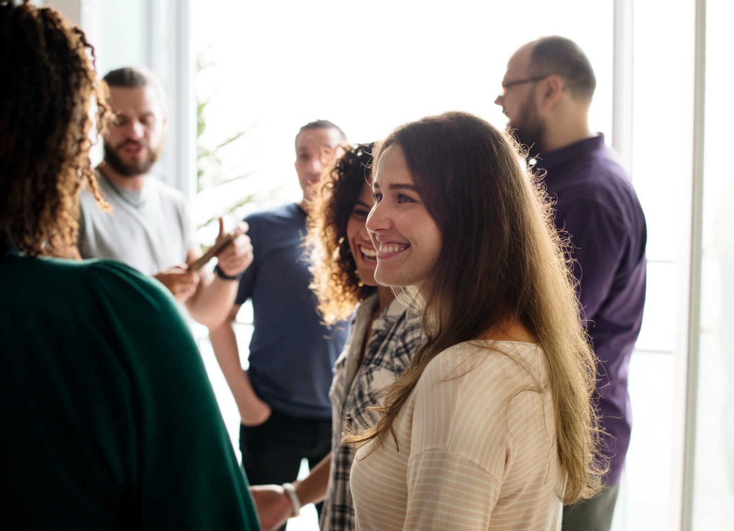 Grupo de pessoas em conversa descontraída, trocando ideias e experiências sobre empreendedorismo digital em ambiente colaborativo.