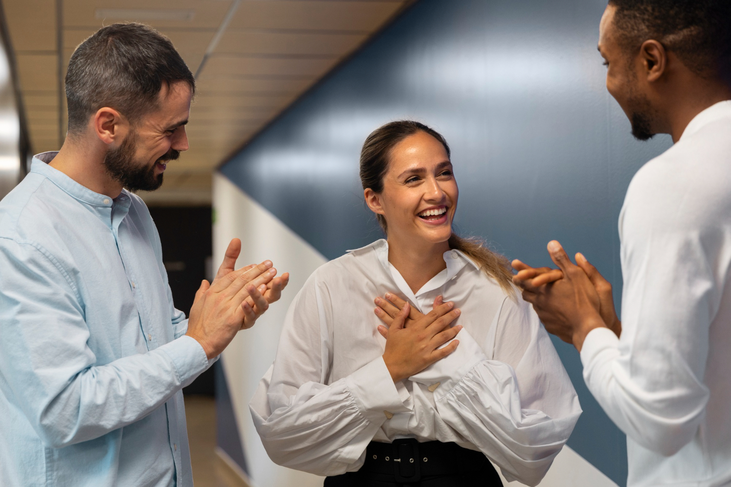 Mulher recebendo feedback de agradecimento com entusiasmo e reconhecimento de seus colegas de trabalho.